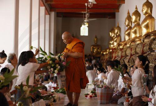 epa13141332 A Thai Buddhist monk is offered flowers by devotees during the floral alms offering ceremony marking the start of Buddhist Lent or 'Khao Phansa' at Wat Phra Chetuphon Wimonmangkalaram Ratchaworamahawihan or Wat Pho in Bangkok, Thailand, 30 July 2026. The traditional floral alms offering is held to mark the start of Buddhist Lent, which begins...