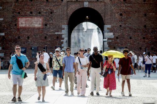 epa13143867 People walk on a hot summer day in Milan, Italy, 31 July 2026. The Italian Ministry of Health issued a 'red-dot' heatwave alert for 19 cities starting 01 August. By 02 August, the number of cities under red alert is expected to increase to 23 out of the 27 being monitored.  EPA/MOURAD BALTI TOUATI