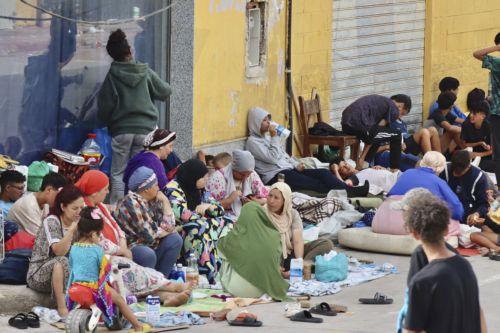 epa13148244 Migrants who entered Ceuta by swimming or on foot from Morocco sit on a street in Ceuta, Spain, 03 August 2026. Surveillance along the Tarajal border, both at sea and on land, as well as new containment measures in the area, including the installation of a barrier in the sea, have reduced the number of people swimming across from Morocco to a...