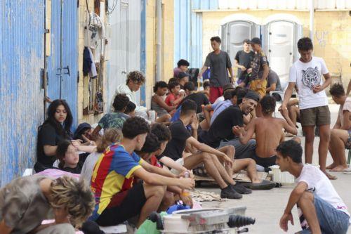 epa13148246 Migrants who entered Ceuta by swimming or on foot from Morocco sit on a street in Ceuta, Spain, 03 August 2026. Surveillance along the Tarajal border, both at sea and on land, as well as new containment measures in the area, including the installation of a barrier in the sea, have reduced the number of people swimming across from Morocco to a...