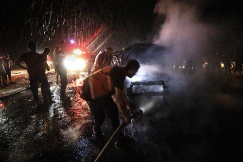 epa13149107 Palestinian Civil Defense personnel extinguish a fire in a destroyed car following an Israeli airstrike on Al-Rashid Road next to the beach in southern Gaza City, 03 August 2026. According to the Gaza Health Ministry,  two Palestinians were killed in the strike.  EPA/MOHAMMED SABER