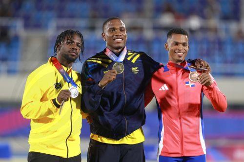 epa13149203 Ronal Longa (C) of Colombia, gold medalist; Bouwahjgie Mkrumie (L) of Jamaica, silver medalist; and Melbin Marcelino of the Dominican Republic, bronze medalist, pose at the awards ceremony for the Men's 100 m during the XXV Central American and Caribbean Games Santo Domingo 2026, in Santo Domingo, Dominican Republic, 03 August 2026.  EPA/ORLANDO...