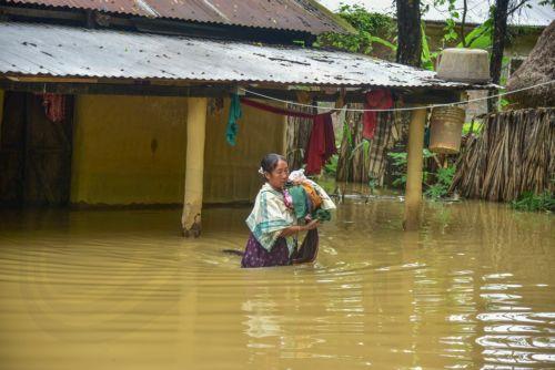 epa13151285 A woaman carries her belongings near her partially submerged house following heavy monsoon rains in Kalapani village, Nagaon district, Assam, India, 05 August 2026. According to the Assam State Disaster Management Authority (ASDMA), the death toll from severe flooding in the north-eastern state of Assam has risen to 89, with over 200,000...