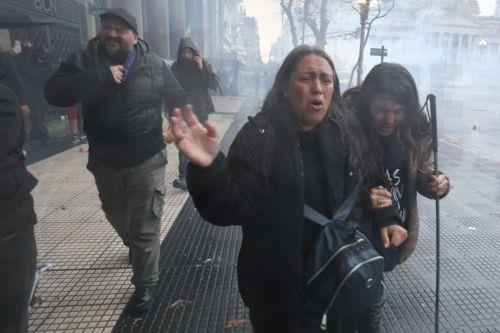 epa13154754 People run during a clash between protesters and police officers at a demonstration against a bill promoted by the government of President Javier Milei introducing changes to eviction procedures, expropriations, and the use of burned land, in Buenos Aires, Argentina, 06 August 2026.  EPA/Juan Ignacio Roncoroni