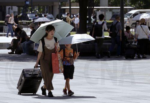 epa13155048 Passersby holding umbrellas to shelter from the sun walk in front of Tokyo Station, in Tokyo, Japan, 07 August 2026. Tokyo has endured a summer of persistent heat, with temperatures frequently exceeding 35 degrees Celsius, prompting authorities to issue heatstroke warnings.  EPA/FRANCK ROBICHON