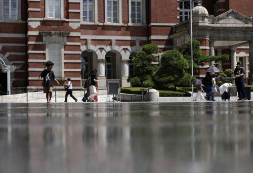 epa13155054 A young boy walks on a water-cooling system in front of Tokyo Station, in Tokyo, Japan, 07 August 2026. Tokyo has endured a summer of persistent heat, with temperatures frequently exceeding 35 degrees Celsius, prompting authorities to issue heatstroke warnings.  EPA/FRANCK ROBICHON