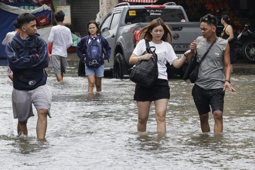 epa13158729 People walk along a flooded road in Rizal province, northeast of Metro Manila, Philippines 10 August 2026. Persistent monsoon rains in Metro Manila and several provinces in the Luzon region caused flooding and triggered evacuations by emergency response units to ensure the safety of residents.  EPA/ROLEX DELA PENA