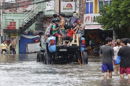 epa13158730 People ride a pick-up truck moving along a flooded road in Rizal province, northeast of Metro Manila, Philippines 10 August 2026. Persistent monsoon rains in Metro Manila and several provinces in the Luzon region caused flooding and triggered evacuations by emergency response units to ensure the safety of residents.  EPA/ROLEX DELA PENA