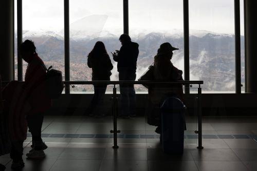 epa13177921 People look at snow-capped mountains surrounding La Paz from El Alto, Bolivia, 18 August 2026. Heavy snowfall in at least four departments forced authorities to temporarily suspend or restrict road travel on several routes to prevent accidents.  EPA/LUIS GANDARILLAS