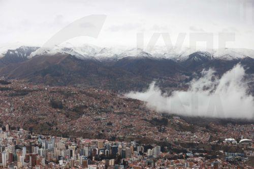epa13177926 Snow-covered mountains surrounding La Paz are seen from El Alto, Bolivia, 18 August 2026. Heavy snowfall in at least four departments forced authorities to temporarily suspend or restrict road travel on several routes to prevent accidents.  EPA/LUIS GANDARILLAS