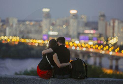 epa13181935 A young couple sits in front of a city view in Kyiv, Ukraine, 20 August 2026, amid the ongoing Russian invasion.  EPA/SERGEY DOLZHENKO 124538