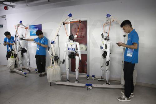 epa13186083 Team members stand next to humanoid robots during the 2026 World Humanoid Robot Games at the National Speed Skating Oval in Beijing, China, 23 August, 2026. The 2026 World Humanoid Robot Games are being held in Beijing until 26 August.  EPA/ANDRES MARTINEZ CASARES