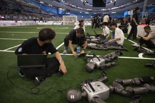 epa13186091 Team members prepare humanoid robots for a football event during the 2026 World Humanoid Robot Games at the National Speed Skating Oval in Beijing, China, 23 August 2026. The 2026 World Humanoid Robot Games are being held in Beijing until 26 August.  EPA/ANDRES MARTINEZ CASARES