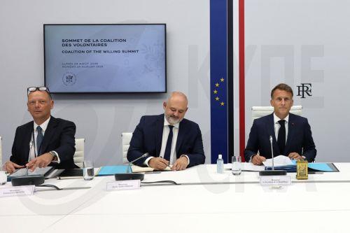 epa13188698 French President Emmanuel Macron (L) co-chairs a video conference meeting of the Coalition of the Willing group of pro-Ukrainian countries to mark the 35th anniversary of Ukraine's independence, at the Elysee Palace in Paris, France, 24 August 2026. While the British prime minister chairs the meeting on the ground in Kyiv, the French president...