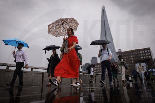 epaselect epa13194056 Commuters holding umbrellas cross London Bridge during heavy rainfall in London, Britain, 27 August 2026. The heavy rain forecast comes as 71 percent of England and all of Wales remain officially in drought, even as the Met Office issues thunderstorm warnings across the country with up to a month’s worth of rain potentially falling on...