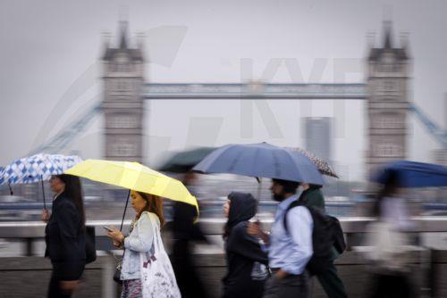 epa13194101 Commuters holding umbrellas cross London Bridge during heavy rainfall in London, Britain, 27 August 2026. The heavy rain forecast comes as 71 percent of England and all of Wales remain officially in drought, even as the Met Office issues thunderstorm warnings across the country with up to a month’s worth of rain potentially falling on parched...