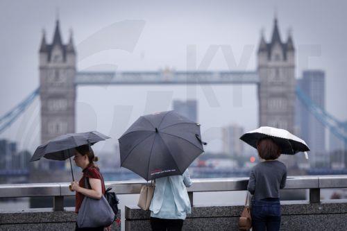 epa13194102 Commuters holding umbrellas cross London Bridge during heavy rainfall in London, Britain, 27 August 2026. The heavy rain forecast comes as 71 percent of England and all of Wales remain officially in drought, even as the Met Office issues thunderstorm warnings across the country with up to a month’s worth of rain potentially falling on parched...
