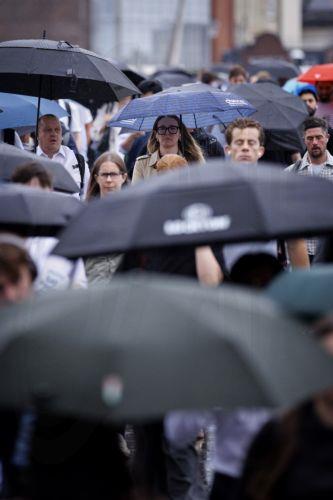 epa13194105 Commuters holding umbrellas cross London Bridge during heavy rainfall in London, Britain, 27 August 2026. The heavy rain forecast comes as 71 percent of England and all of Wales remain officially in drought, even as the Met Office issues thunderstorm warnings across the country with up to a month’s worth of rain potentially falling on parched...
