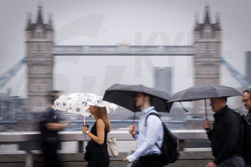 epa13194107 Commuters holding umbrellas cross London Bridge during heavy rainfall in London, Britain, 27 August 2026. The heavy rain forecast comes as 71 percent of England and all of Wales remain officially in drought, even as the Met Office issues thunderstorm warnings across the country with up to a month’s worth of rain potentially falling on parched...