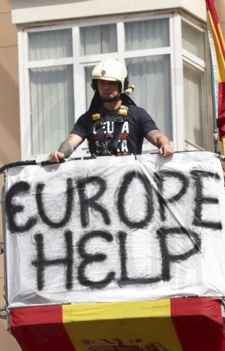 epa13202200 A firefighter protests outside a balcony during a rally called by public servants to demand more 'Resources, Means, and Solutions' amid the migrant crisis outside the offices of the Delegation of the Central Government in Ceuta, Spain, 31 August 2026. Spain faced a massive migration crisis after thousands of people crossed into the North African...