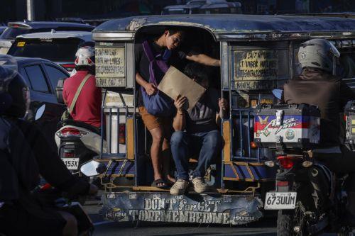 epa13238178 Passengers hold on to the back of a jeepney, or local minibus, along a road in Quezon City, Metro Manila, Philippines, 14 September 2026. A public transport organization called Manibela (steering wheel), went on strike to protest fuel price hikes that have been affected by the Middle East conflict. Manibela leaders have called on the Philippine...