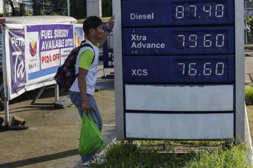 epa13238182 A person takes shade beside a board displaying prices at a fuel station in Quezon City, Metro Manila, Philippines, 14 September 2026. A public transport organization called Manibela (steering wheel), went on strike to protest fuel price hikes that have been affected by the Middle East conflict. Manibela leaders have called on the Philippine...