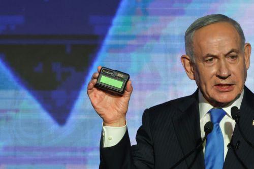 epa13246644 Israeli Prime Minister Benjamin Netanyahu holds a pager as he addresses supporters during a Likud party elections campaign event in Tel Aviv, Israel, 17 September 2026. General elections are scheduled to be held in Israel on 27 October 2026.  EPA/ATEF SAFADI