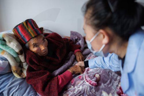 epa13273981 (FILE) - An employee communicates with a woman laying in bed in the Feeding Center for specially distressed persons, during the government organised tour in Shannan, Qusong County, Tibet Autonomous Region, China, 18 June 2023 (reissued on 01 October 2026). 01 October marks the United Nations International Day of Older Persons. This year, the...