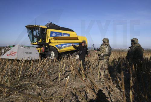epa13277320 Ukrainian servicemen guard farmers from Russian drones as they harvest sunflowers near a frontline in the Zaporizhzhia region, Ukraine, 02 October 2026, amid the ongoing Russian invasion. The territory close to the frontline is extremely dangerous due to Russian FPV drones.  EPA/OLEG MOVCHANIUK