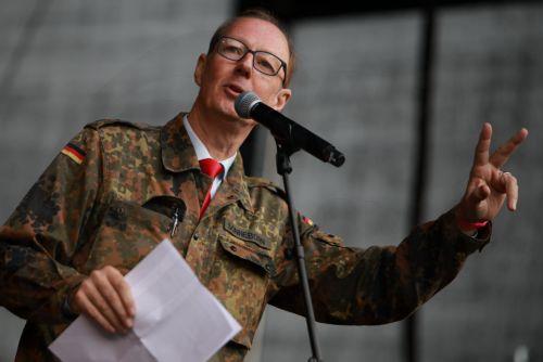 epa13277392 Member of European Parliament Martin Sonneborn speaks during a protest against compulsory military service at the Brandenburg Gate in Berlin, Germany, 02 October 2026.  EPA/CLEMENS BILAN