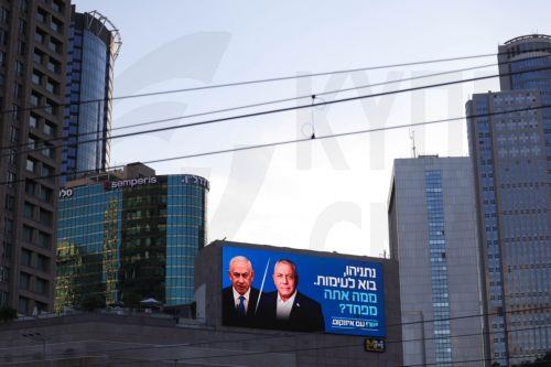 epa13283972 A large election billboard shows Israeli Prime Minister Benjamin Netanyahu (C-L) and leader of the Yashar party, Gadi Eisenkot (C-R), with a message in Hebrew stating 'Netanyahu, come to a debate; what are you afraid of?' in Tel Aviv, Israel, 06 October 2026. Israel will hold elections on 27 October.  EPA/ABIR SULTAN EPA