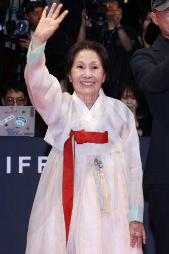 epa13286093 South Korean actress Kim Hye-ja waves as she walks down the red carpet to enter the opening ceremony of the 31st Busan International Film Festival (BIFF) at the outdoor theater of the Busan Cinema Center in Busan, South Korea, 06 October 2026 (issued 07 October 2026). The festival began its 10-day run after the International Federation of Film...