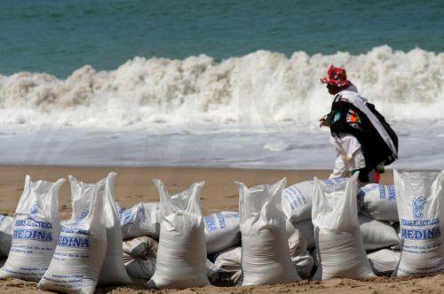 epa13293005 A vendor walks along a beach carrying sandbags to build barricades in anticipation of Hurricane Simon, which reaches Category 2 strength in the Mexican Pacific with sustained winds of 155 kilometers per hour, in Puerto Vallarta, Mexico, 09 October 2026.  EPA/Arturo Montero