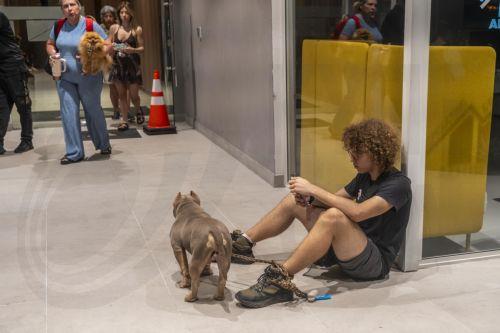 epa13293162 A man with his dog waits outside a building after a magnitude 7.7 earthquake struck southeastern Panama, in Panama City, Panama, 9 October 2026. The Geosciences Institute (IGC) reported that more than a hundred aftershocks have followed the magnitude 7.5 to 7.7 earthquake that struck the southeast of the country, while civil protection sources...
