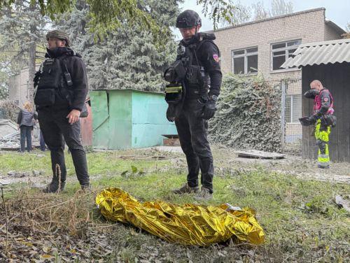 epa13293545 Ukrainian police officers stand near the covered body of a child killed in a Russian attack on a residential area in Zaporizhzhia, Ukraine, 10 October 2026, amid the ongoing Russian invasion. At least five people, including two children, were killed and 11 others injured in overnight Russian strikes on the residential area, according to the...