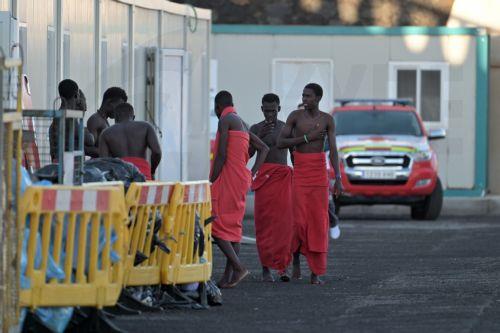 epa13315097 Sub-Saharan migrants, who were rescued by the Rescue Navy while attempting to reach Spain, wait to get assistance from Red Cross members, at La Restinga dock in El Hierro, Canary Islands, Spain, 19 October 2026. A total of 145 Sub-Saharan migrants were rescued off the shore while attempting to reach Spain.  EPA/Gelmert Finol