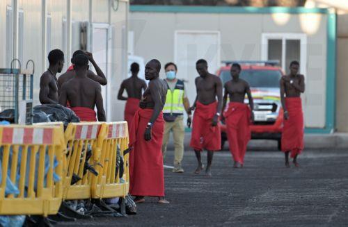 epa13315099 Sub-Saharan migrants, who were rescued by the Rescue Navy while attempting to reach Spain, wait to get assistance from Red Cross members, at La Restinga dock in El Hierro, Canary Islands, Spain, 19 October 2026. A total of 145 Sub-Saharan migrants were rescued off the shore while attempting to reach Spain.  EPA/Gelmert Finol