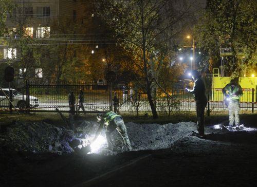 epa13333633 Ukrainian officials inspect a crater at the site of a Russian missile strike on a residential area in Kyiv, Ukraine, 26 October 2026, amid the ongoing Russian invasion. At least one person died, and 10 others were injured during the overnight Russian ballistic missile attack, according to the State Emergency Service report.  EPA/SERGEY DOLZHENKO