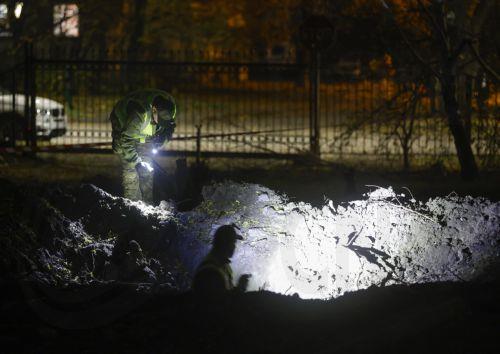 epa13333635 Ukrainian experts inspect a crater at the site of a Russian missile strike on a residential area in Kyiv, Ukraine, 26 October 2026, amid the ongoing Russian invasion. At least one person died, and 10 others were injured during the overnight Russian ballistic missile attack, according to the State Emergency Service report.  EPA/SERGEY DOLZHENKO