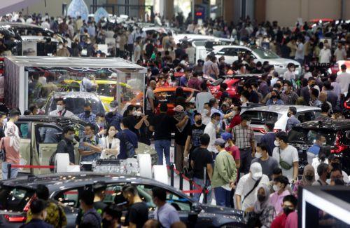epa10123967 Visitors look at and browse through cars during the Gaikindo Indonesia International Auto Show 2022 in Tangerang, Indonesia, 16 August 2022. The Gaikindo Indonesia International Auto Show (GIIAS 2022) opened to the public from 11 to 21 August 2022. The Association of Indonesian Automotive Industries reported that the sales of new cars in...