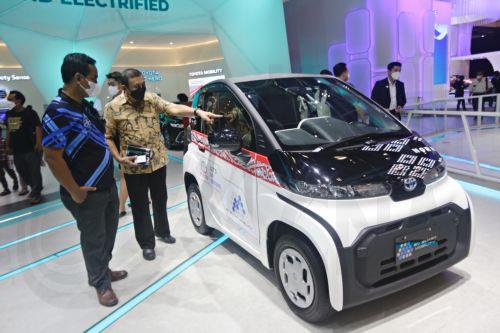 epa10123970 Visitors look at the Japanese-made electric car Toyota EV Smart during the Gaikindo Indonesia International Auto Show 2022 in Tangerang, Indonesia, 16 August 2022. The Gaikindo Indonesia International Auto Show (GIIAS 2022) opened to the public from 11 to 21 August 2022. The Association of Indonesian Automotive Industries reported that the sales...
