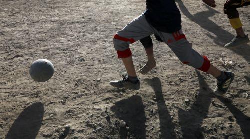 epa10315090 Yemeni children play soccer amid a dust storm in a field on the eve of World Children's Day, in Sana'a, Yemen, 19 November 2022. World Children's Day is observed annually on 20 November to highlight children in demanding action to protect and promote child rights as well as improving children's welfare. It also marks the Declaration of the...