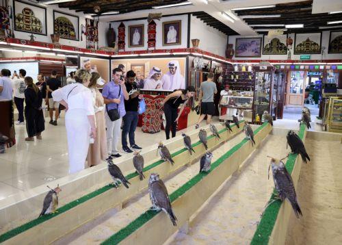 epa10348415 Tourists visit the Falcon market in Souq Waqif, an old marketplace in Doha, Qatar, 04 December 2022. The falcon is the national bird of Qatar and part of the culture of the Qatari people. The Falcon market in Souq Waqif offers special accessories and falcons sales and play as  one of the major tourists attractions of the country as over one...
