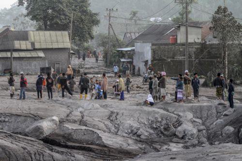 epa10349047 Villagers inspect the area buried in volcanic ash from the eruption of Mount Semeru at Kajar Kuning village in Lumajang, East Java, Indonesia, 05 December 2022. Authorities has raised Mount Semeru alert status to the highest level following its eruption early on 04 December 2022 forcing around two thousands villagers to flee their home. The...