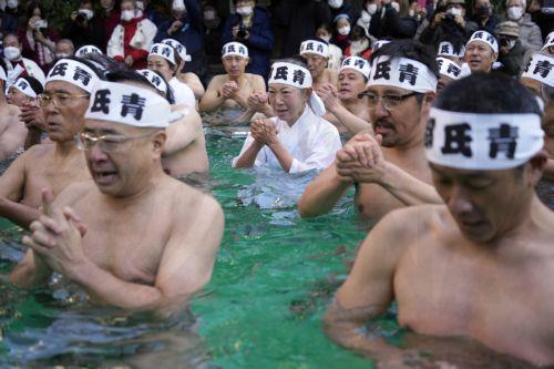 epa10395002 Men and women bathe in ice-cold water during a ceremony at Teppozu Inari Shrine in Tokyo, Japan, 08 January 2023. Forty men and women took part in the ice water endurance ceremony to purify their souls and pray for good health in the new year.  EPA/FRANCK ROBICHON