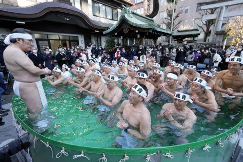 epaselect epa10394993 Men and women bathe in ice-cold water during a ceremony at Teppozu Inari Shrine in Tokyo, Japan, 08 January 2023. Forty men and women took part in the ice water endurance ceremony to purify their souls and pray for good health in the new year.  EPA/FRANCK ROBICHON
