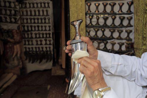 epa10395140 A Yemeni vendor displays traditional jambias for sale in a shop of a market in the old city of Sana'a, Yemen, 07 January 2023 (issued 08 January 2023). The famous Yemeni 'Jambia', dating back more than 2000 years, is a curved and double-edged dagger and worn proudly by the majority of Yemeni men, including adults and children, around the waist....