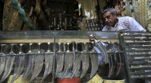 epa10395139 A Yemeni vendor displays traditional jambias for sale in a shop of a market in the old city of Sana'a, Yemen, 07 January 2023 (issued 08 January 2023). The famous Yemeni 'Jambia', dating back more than 2000 years, is a curved and double-edged dagger and worn proudly by the majority of Yemeni men, including adults and children, around the waist....