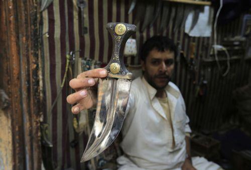 epa10395145 A Yemeni craftsman holds a traditional jambia after he finished working on it in a shop of a market in the old city of Sana'a, Yemen, 07 January 2023 (issued 08 January 2023). The famous Yemeni 'Jambia', dating back more than 2000 years, is a curved and double-edged dagger and worn proudly by the majority of Yemeni men, including adults and...