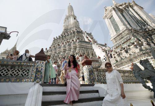 epa10424391 Tourist, dressed in Thai traditional costumes rented from a clothing rental shop, during a visit to Wat Arun or Temple of Dawn in Bangkok, Thailand, 23 January 2023. Thailand's tourism and business related activities are in recovery stimulated by the influx of Chinese tourists after China lifted COVID-19 travel restrictions. Thailand is...
